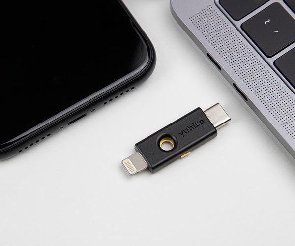 Yubikey 5ci next to an iPhone and Mac laptop